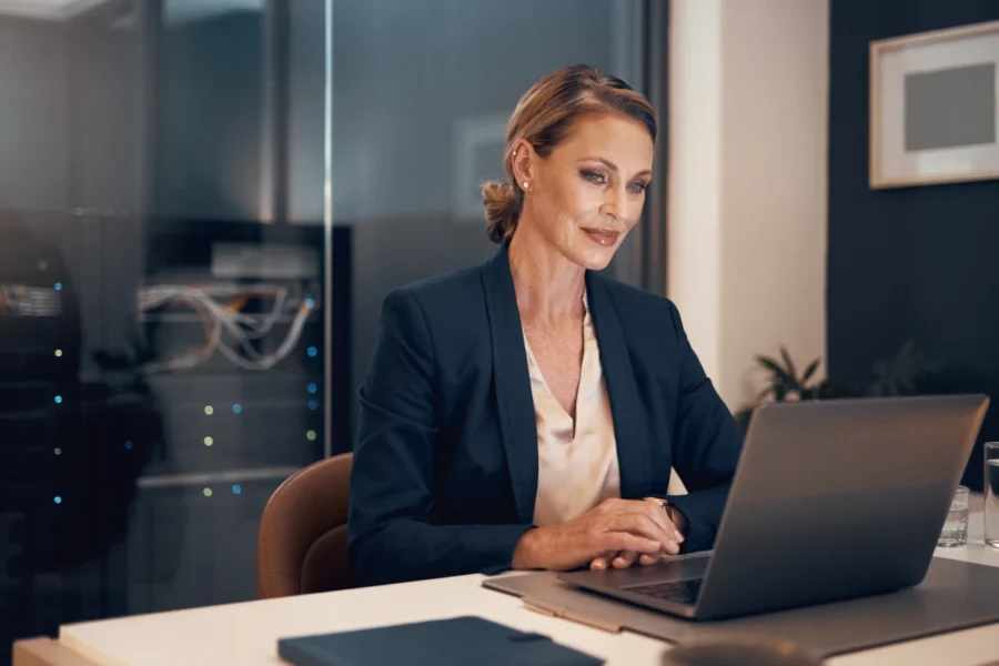 Attractive female founder reviewing business hosting in a modern office.